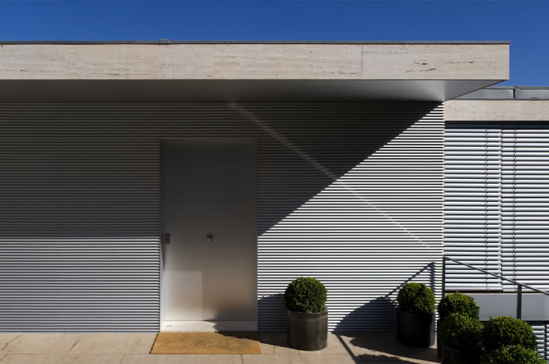 Fachada de vivienda con cerramiento metálico tipo lamas modernas