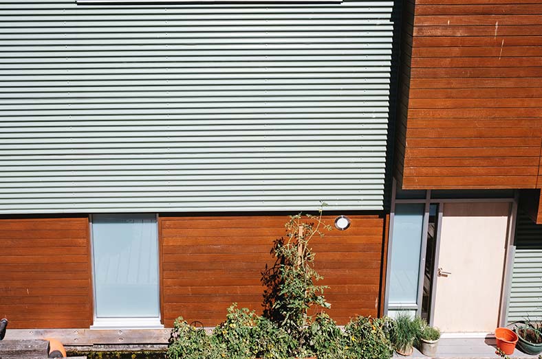Fachada de casa moderna con combinación de chapa metálica y madera natural